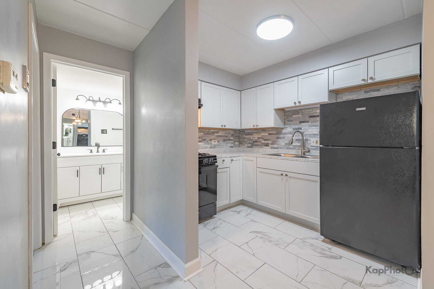 669 Chappel Avenue, Unit 1A Calumet City, IL 60409 - Photo 10 of 24 a kitchen with a refrigerator sink and cabinets