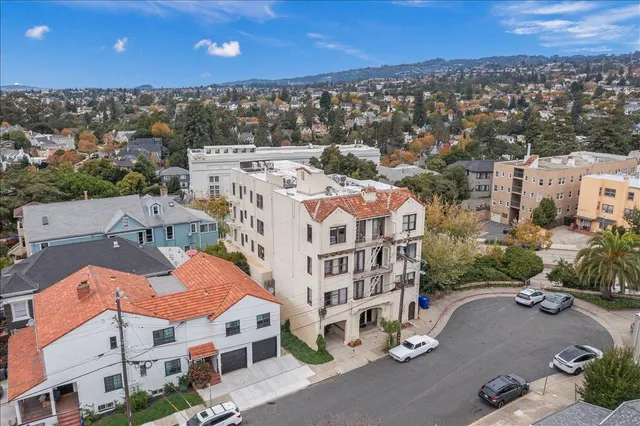 a front view of a building with lot of cars and trees