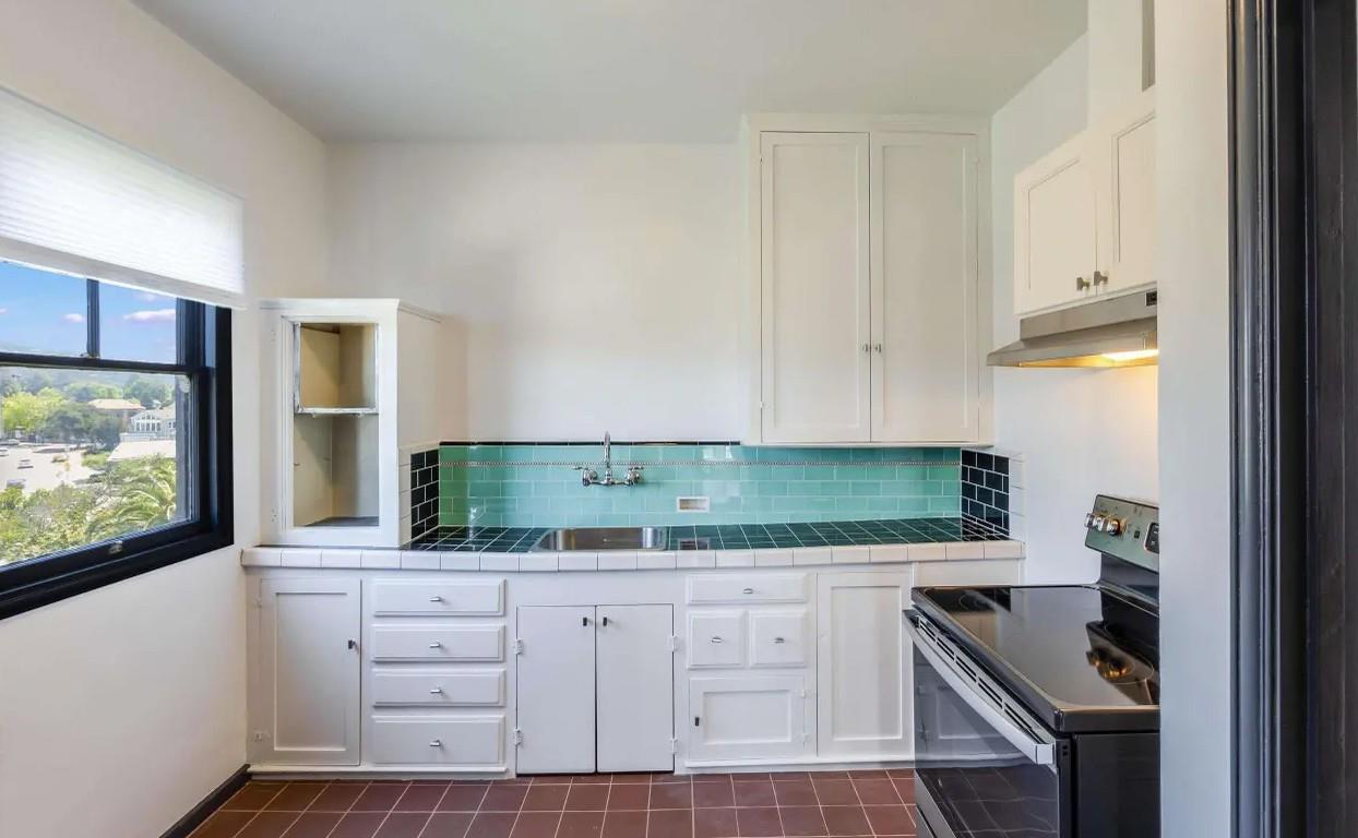 3719 Emerson Street Oakland, CA 94610 - Photo 13 of 34 a kitchen with white cabinets and a stove