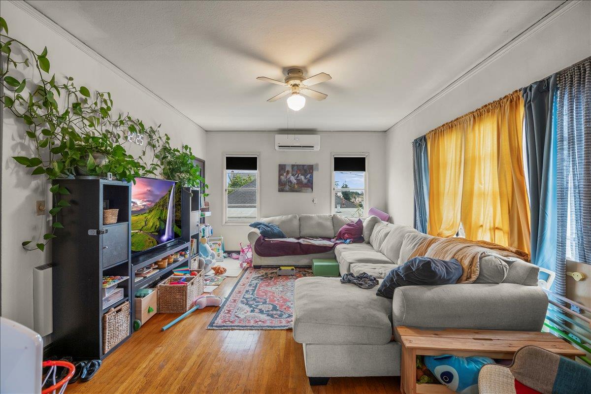 3719 Emerson Street Oakland, CA 94610 - Photo 22 of 34 a living room with furniture a flat screen tv and a large window