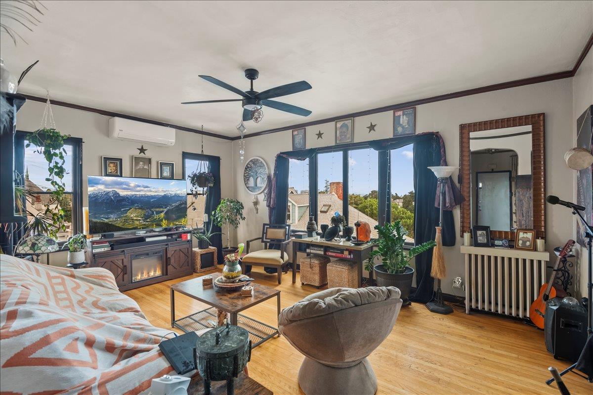 3719 Emerson Street Oakland, CA 94610 - Photo 23 of 34 a living room with furniture a flat screen tv and floor to ceiling window