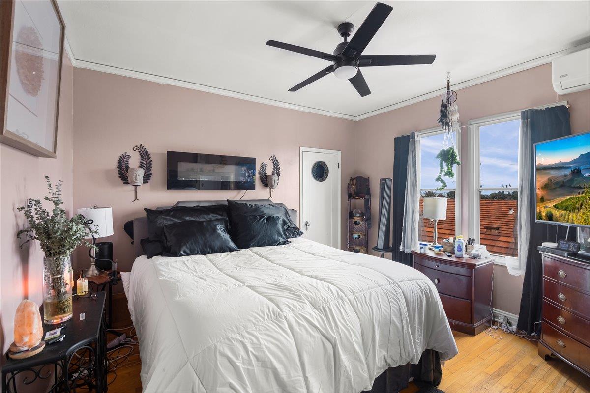 3719 Emerson Street Oakland, CA 94610 - Photo 30 of 34 a bedroom with a large bed and a flat tv screen on dresser