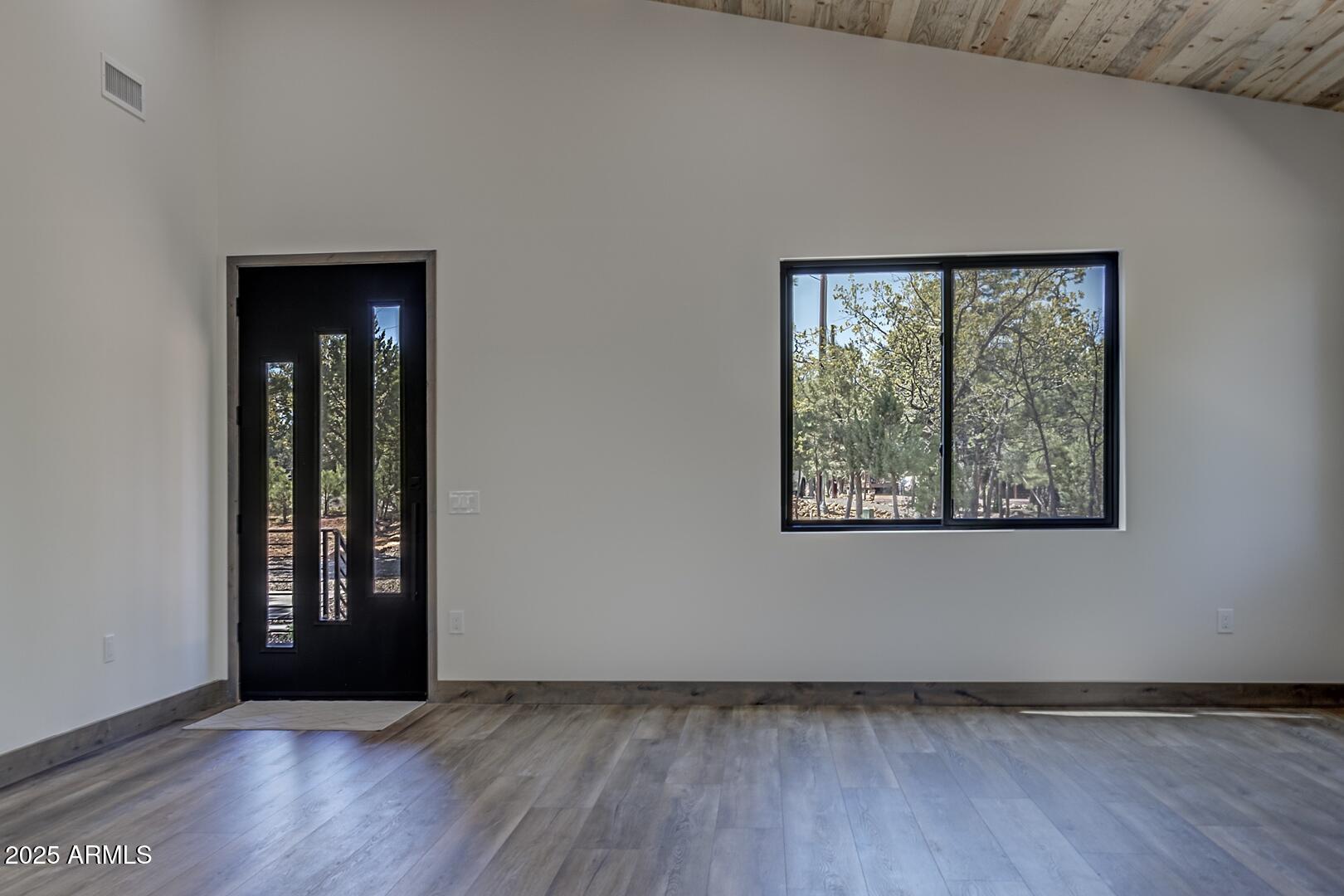 2965 Eagle Ridge Circle Happy Jack, AZ 86024 - Photo 13 of 54 an empty room with wooden floor and windows