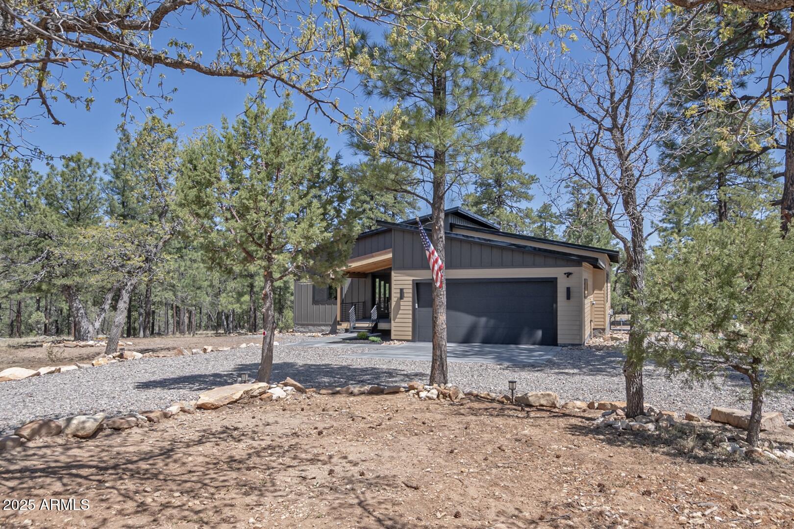 2965 Eagle Ridge Circle Happy Jack, AZ 86024 - Photo 2 of 54 a front view of a house with a yard and garage