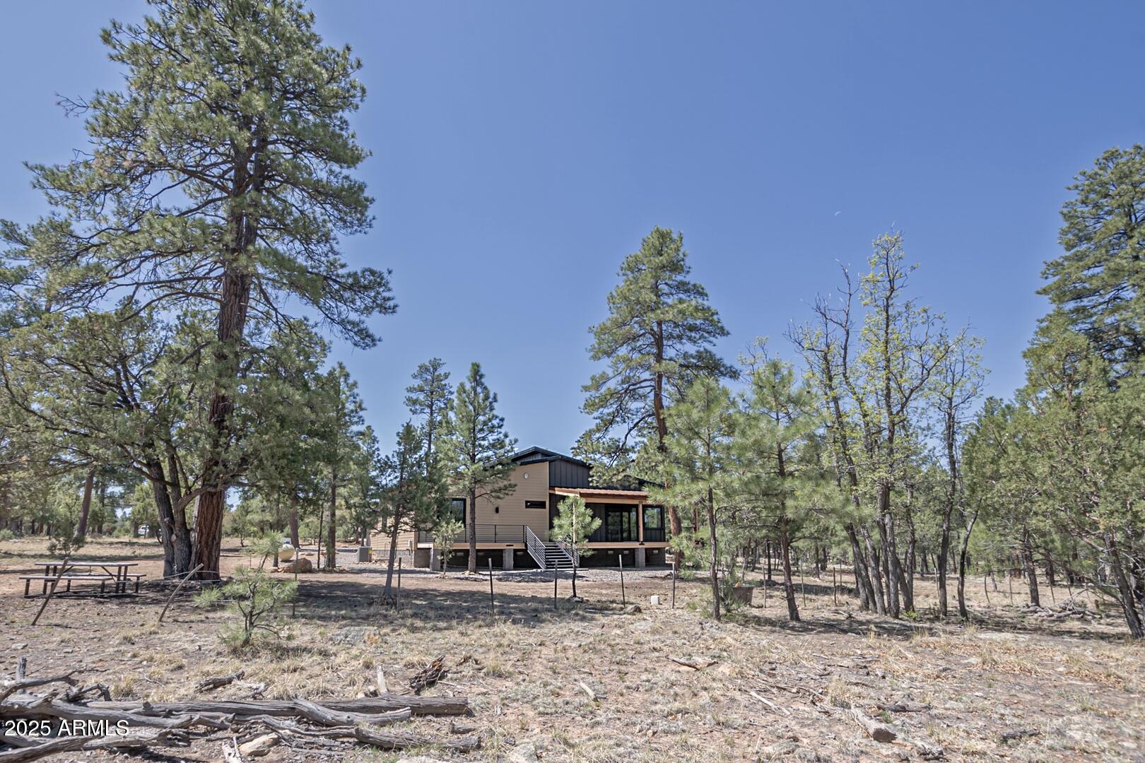2965 Eagle Ridge Circle Happy Jack, AZ 86024 - Photo 42 of 54 a front view of a house with a yard and trees