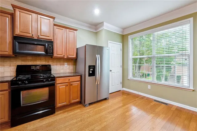 a kitchen with stainless steel appliances granite countertop a stove a refrigerator and a stove top oven