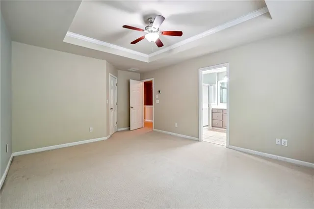 an empty room with ceiling fan and windows