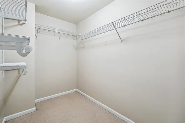 an empty room with ceiling fan and windows