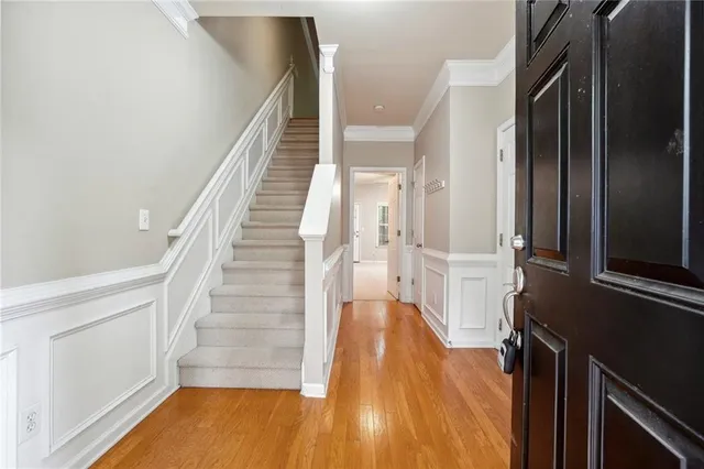 a view of a hallway with wooden floor and staircase