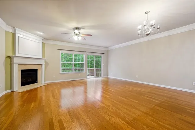 a view of an empty room with chandelier and a fireplace