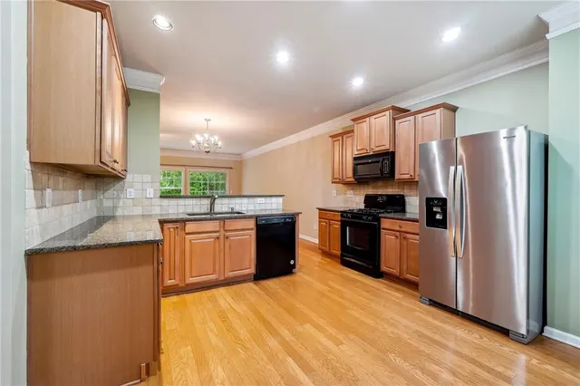 a large kitchen with stainless steel appliances sink a microwave and cabinets