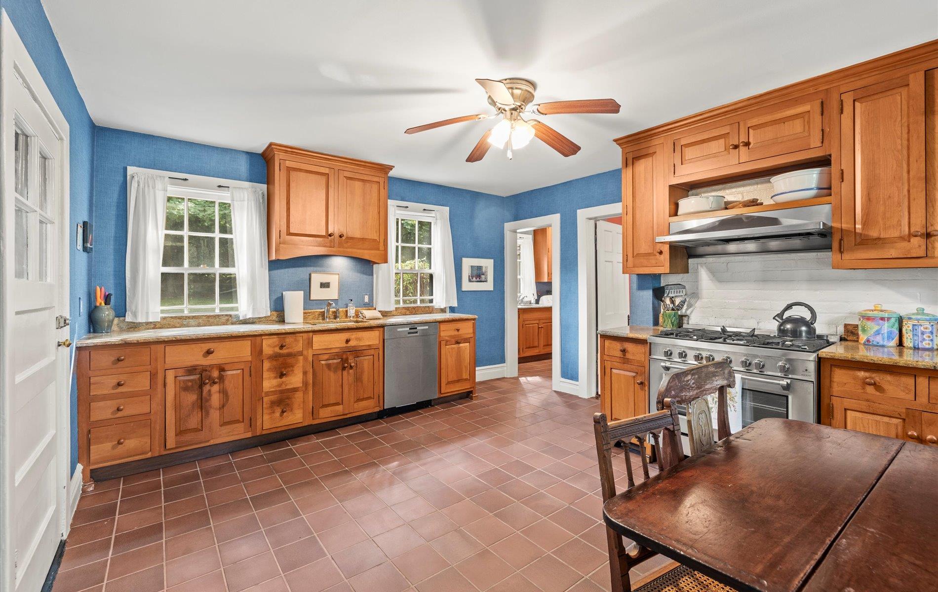 101 Forest Road Queens, NY 11363 - Photo 9 of 50 a large kitchen with stainless steel appliances granite countertop a stove top oven a sink a dining table and chairs with wooden floor