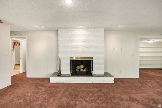1365 Sumac Drive Logan, UT 84321 - Photo 32 of 66 Living area featuring a painted brick fireplace with a brass surround and a tiled hearth