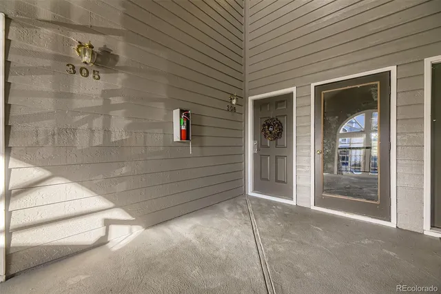 a view of a porch with a door and wooden floor