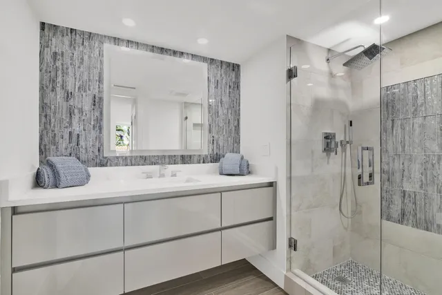 a bathroom with a shower sink and mirror
