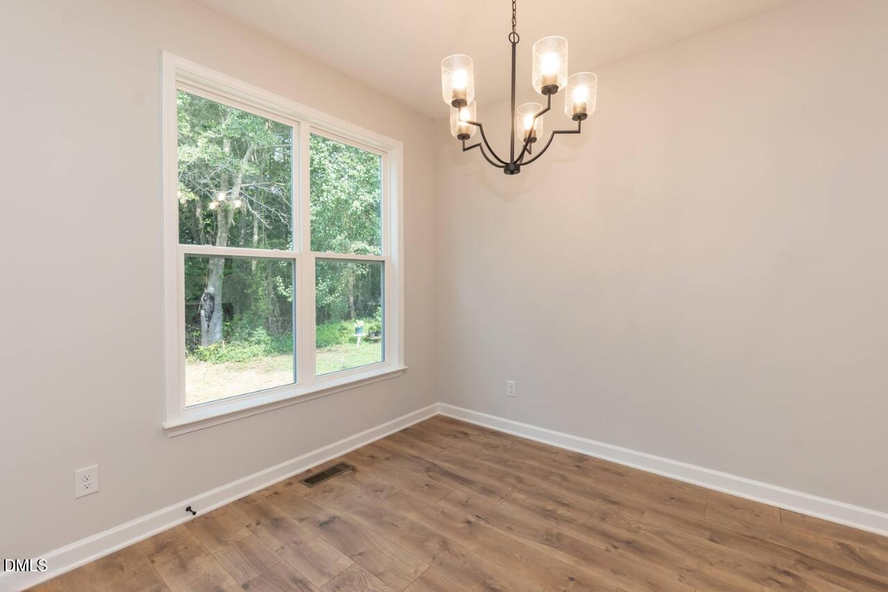1020 Raven Street Durham, NC 27704 - Photo 3 of 13 an empty room with wooden floor fan and windows