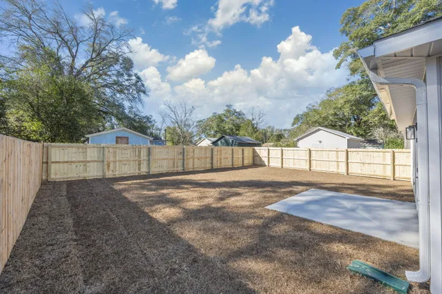 a view of house with backyard and trees