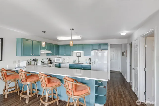 a kitchen with stainless steel appliances granite countertop a sink and a refrigerator