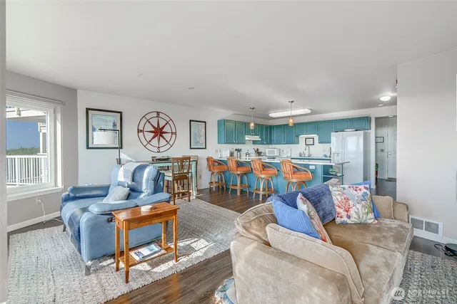 a living room with furniture kitchen view and a window