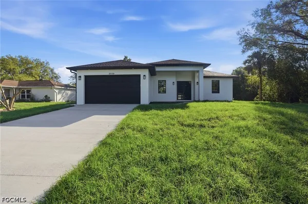 a view of a house with a yard and garage