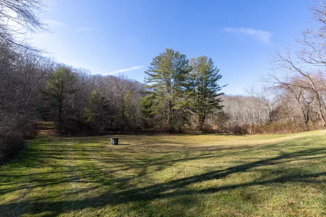 a view of a yard with wooden fence