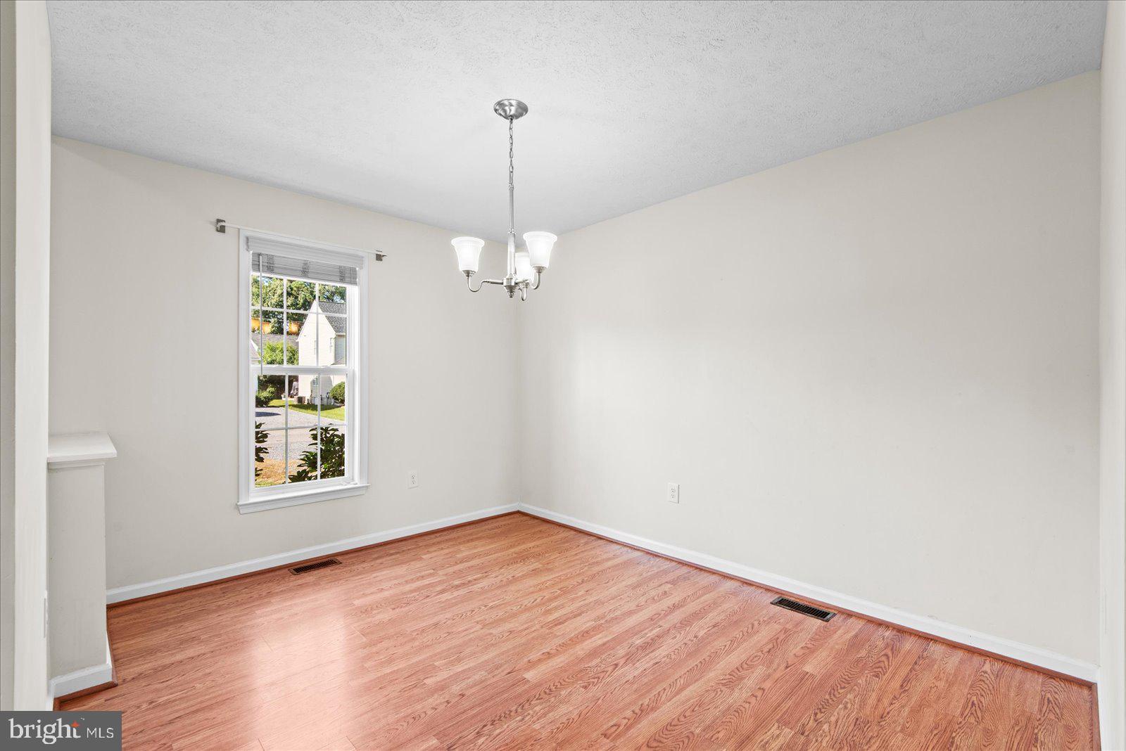 310 3rd Street Colonial Beach, VA 22443 - Photo 12 of 38 a view of an empty room with window and wooden floor