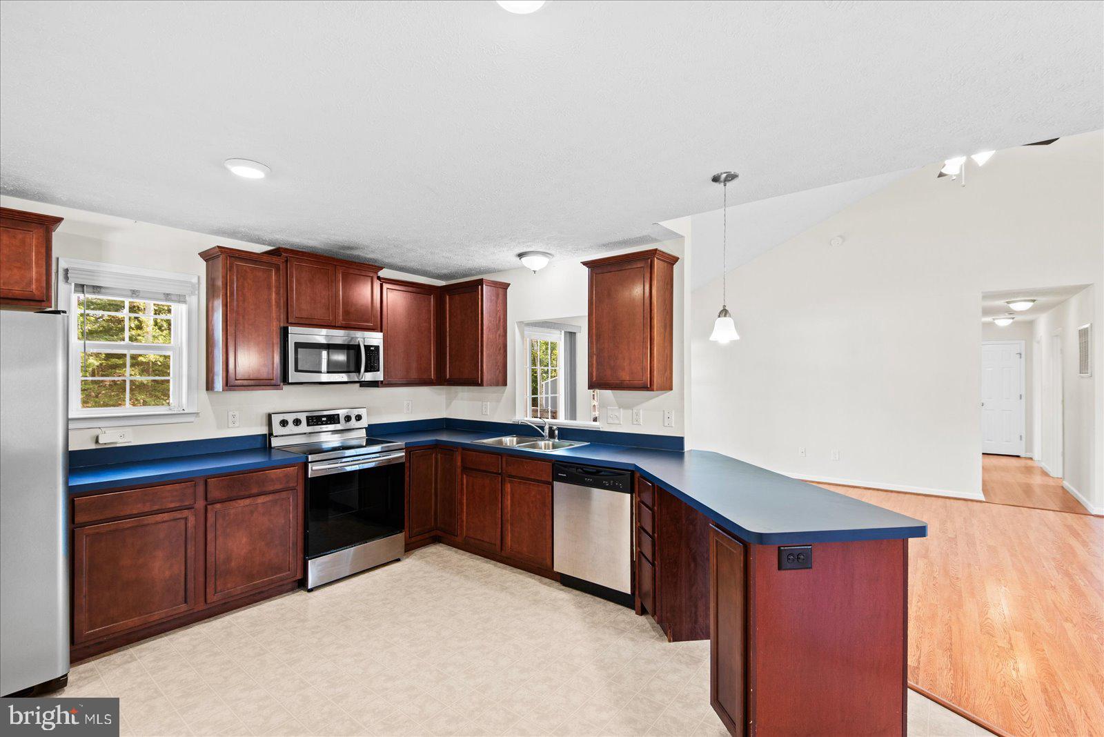 310 3rd Street Colonial Beach, VA 22443 - Photo 16 of 38 a kitchen with stainless steel appliances granite countertop wooden cabinets a stove top oven a sink and dishwasher