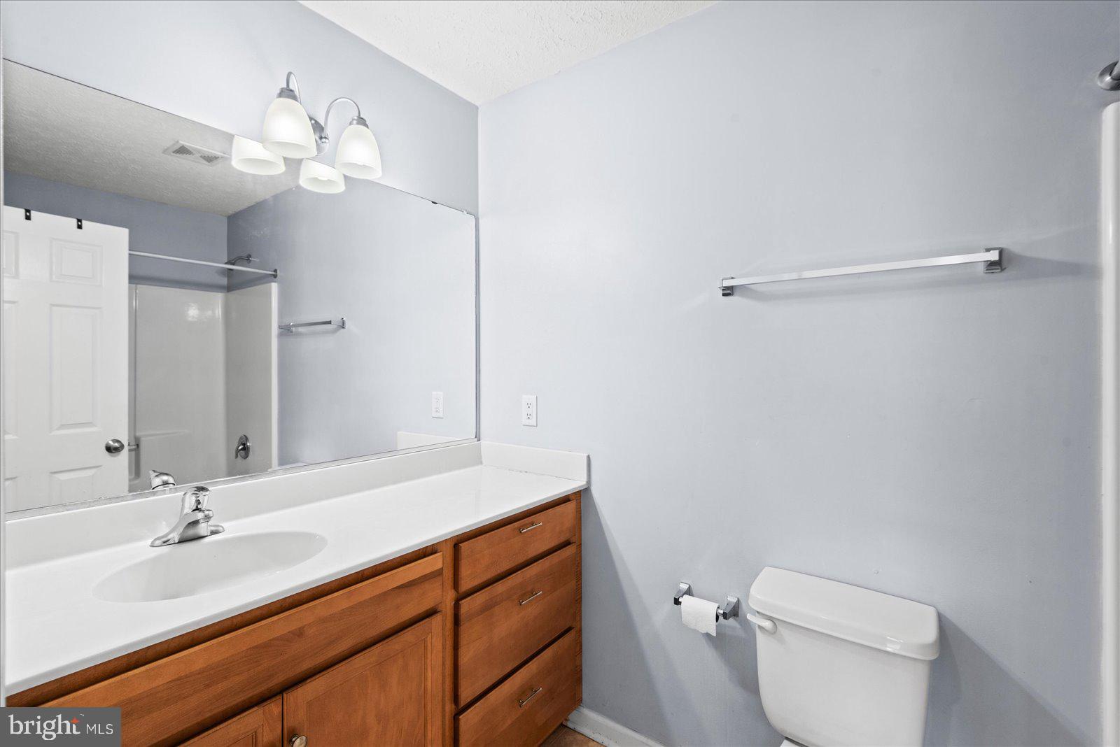 310 3rd Street Colonial Beach, VA 22443 - Photo 31 of 38 a bathroom with a toilet a sink a mirror and vanity