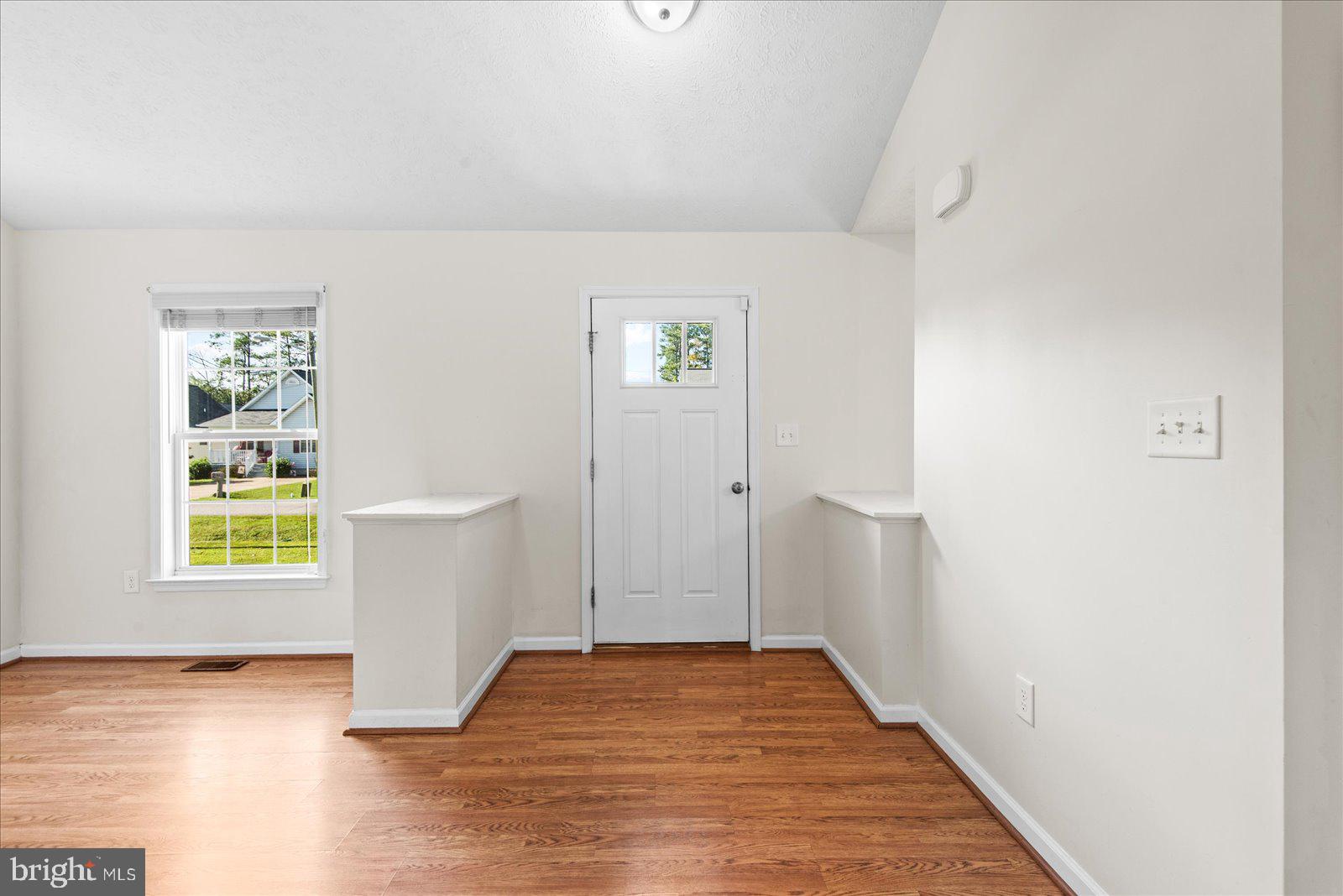 310 3rd Street Colonial Beach, VA 22443 - Photo 7 of 38 a view of an empty room with a window and wooden floor