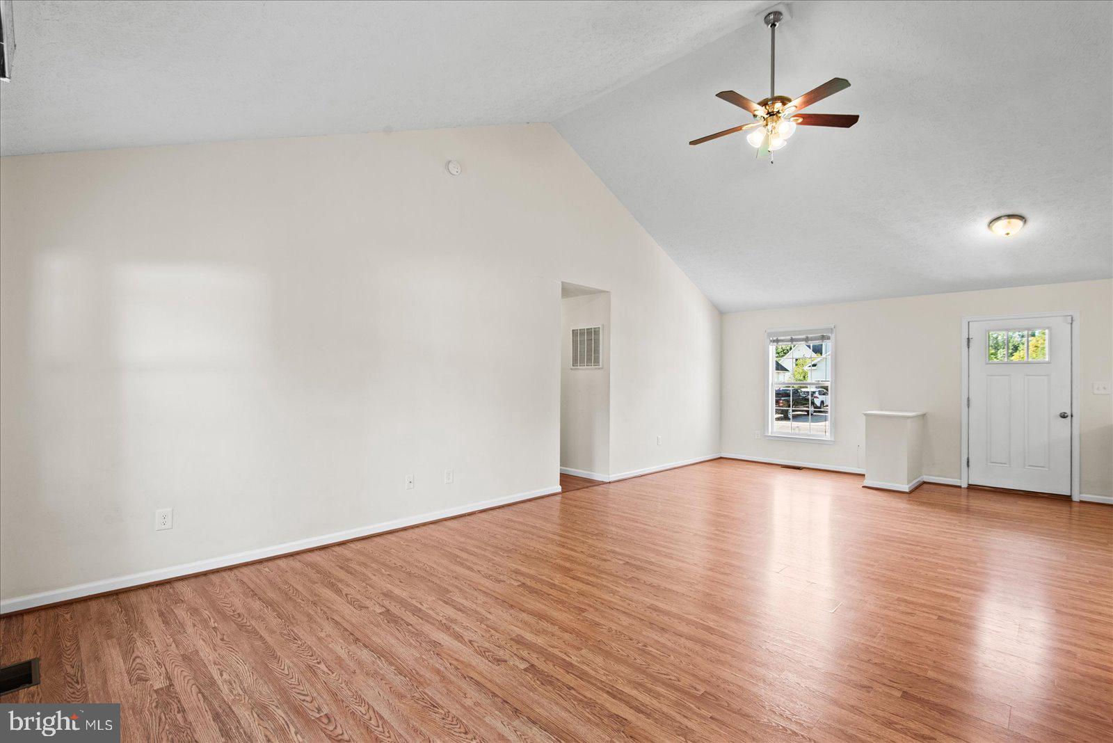 310 3rd Street Colonial Beach, VA 22443 - Photo 10 of 38 an empty room with wooden floor chandelier fan and windows