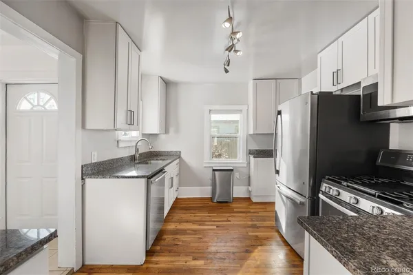 a kitchen with granite countertop a refrigerator and a sink