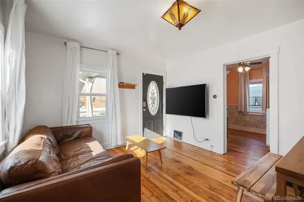 a living room with furniture and a wooden floor