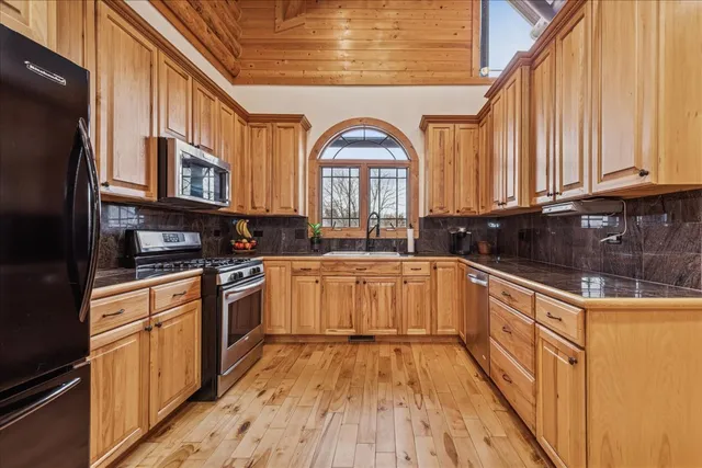 a kitchen with stainless steel appliances granite countertop a stove a sink dishwasher and a refrigerator