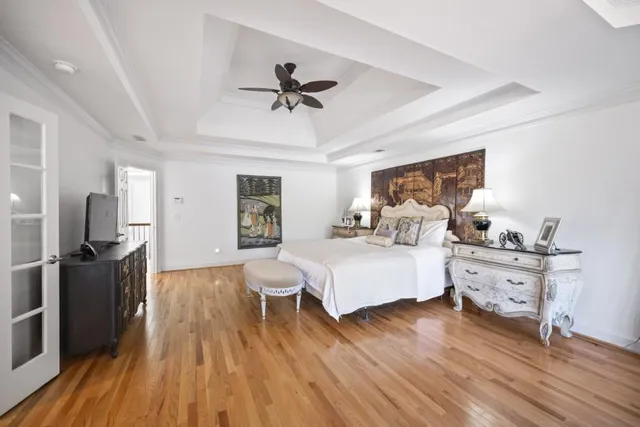 a spacious bedroom with a bed and wooden floor