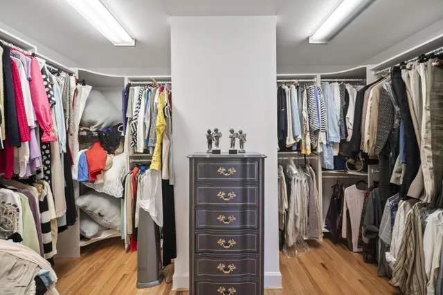 a view of walk in closet with clothes and shoes