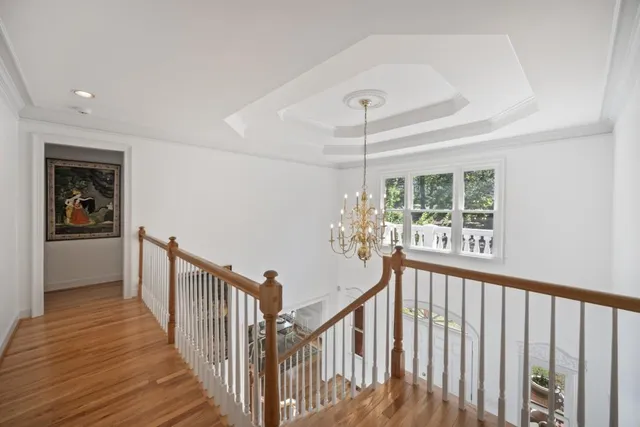 a view of a hallway with wooden floor and stairs
