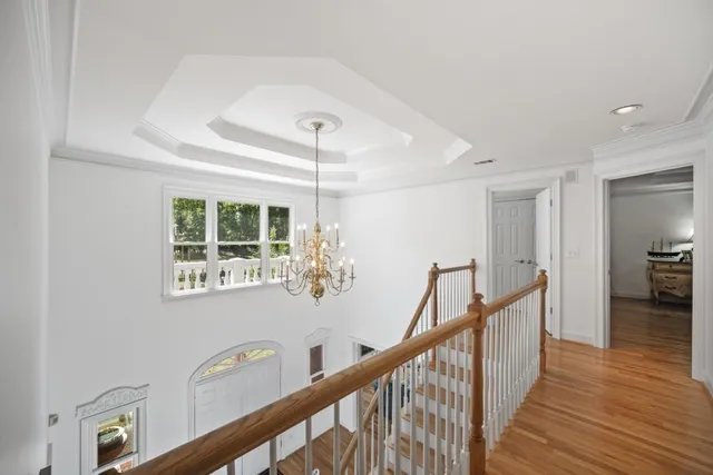 a view of a hallway with wooden floor and staircase