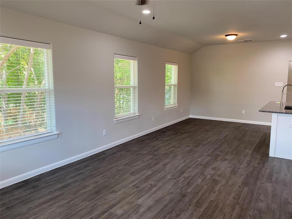 313 East Nelson Street Denison, TX 75021 - Photo 3 of 21 a view of an empty room with wooden floor and a window