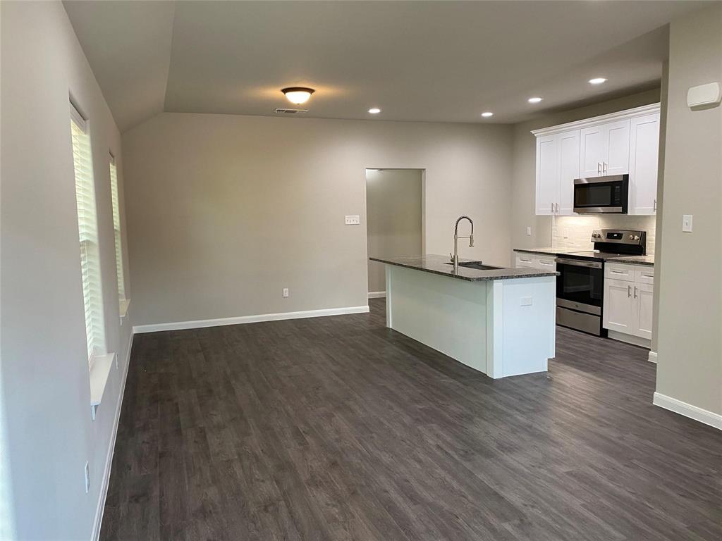 313 East Nelson Street Denison, TX 75021 - Photo 5 of 21 a view of kitchen with microwave stove refrigerator and cabinets