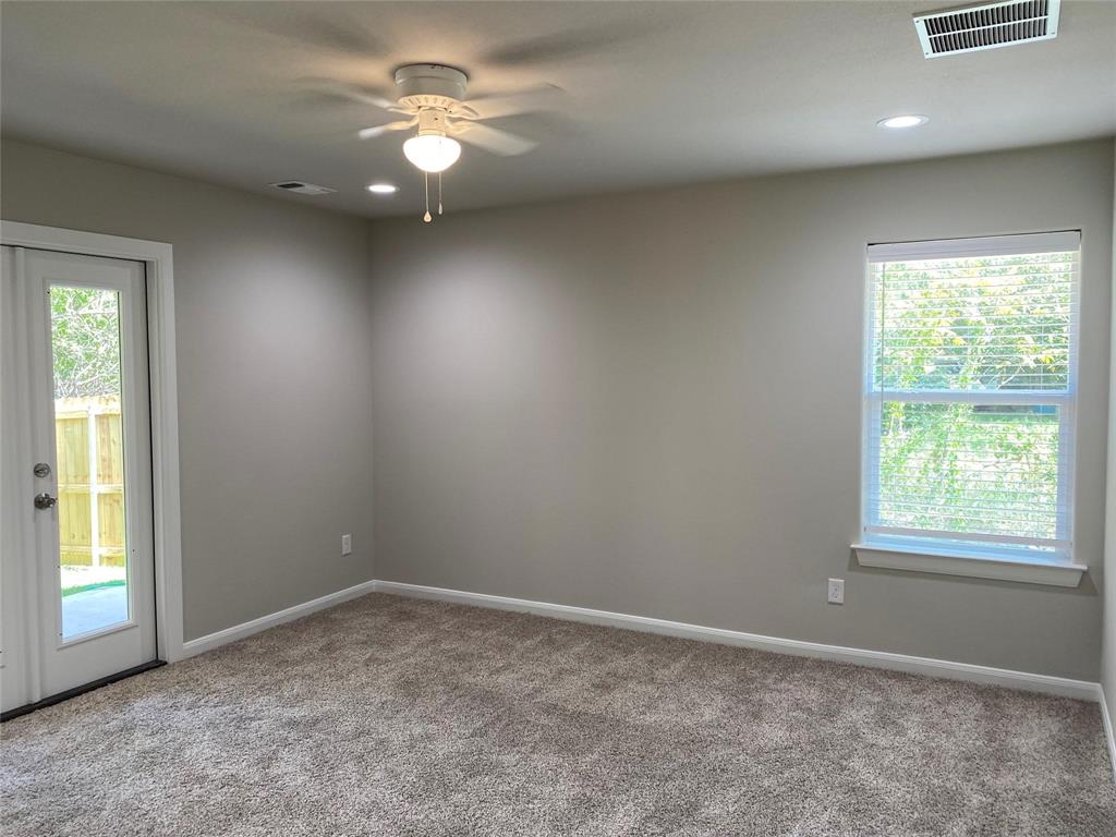 313 East Nelson Street Denison, TX 75021 - Photo 8 of 21 an empty room with a window and a fan