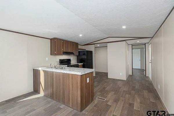 a kitchen with granite countertop a refrigerator stove top oven and sink