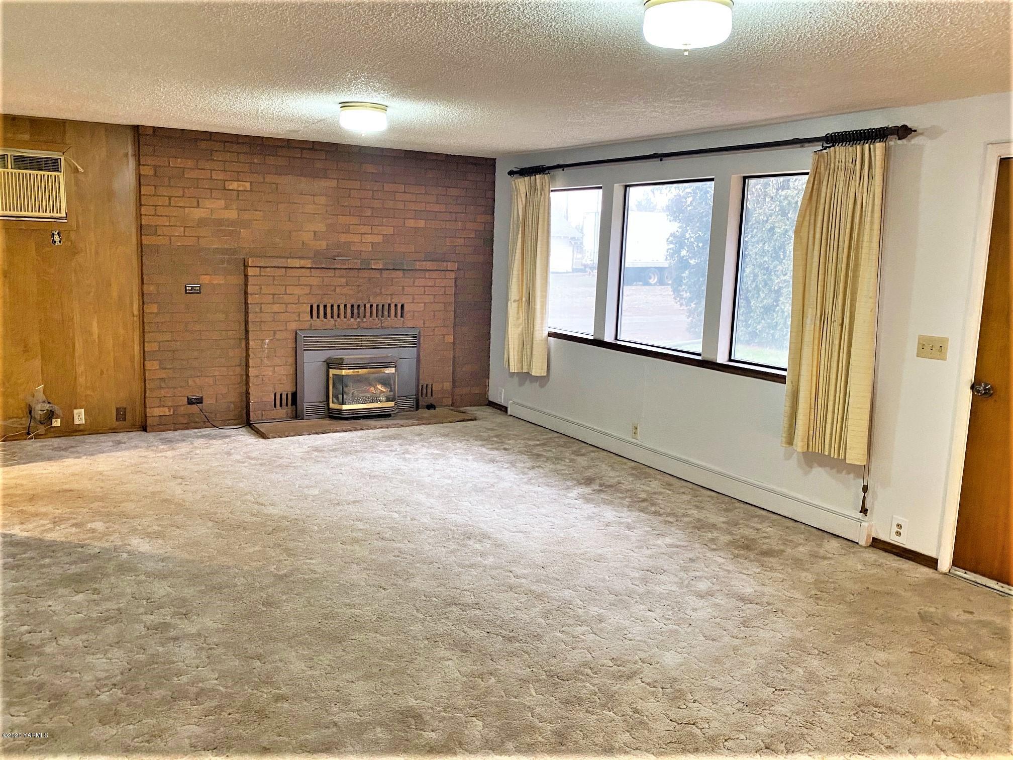 701 Grandview Pavement Road Grandview, WA 98930 - Photo 2 of 14 a view of an empty room with a fireplace and a window