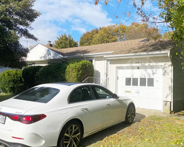 a car parked in front of a white house