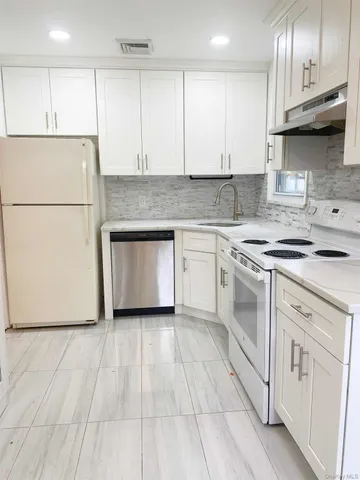 a kitchen with granite countertop a sink stove and cabinets
