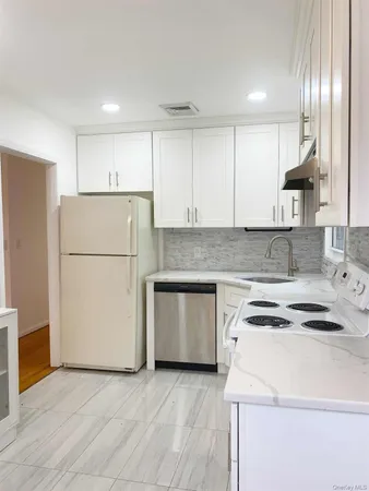 a kitchen with a white stove top oven and refrigerator
