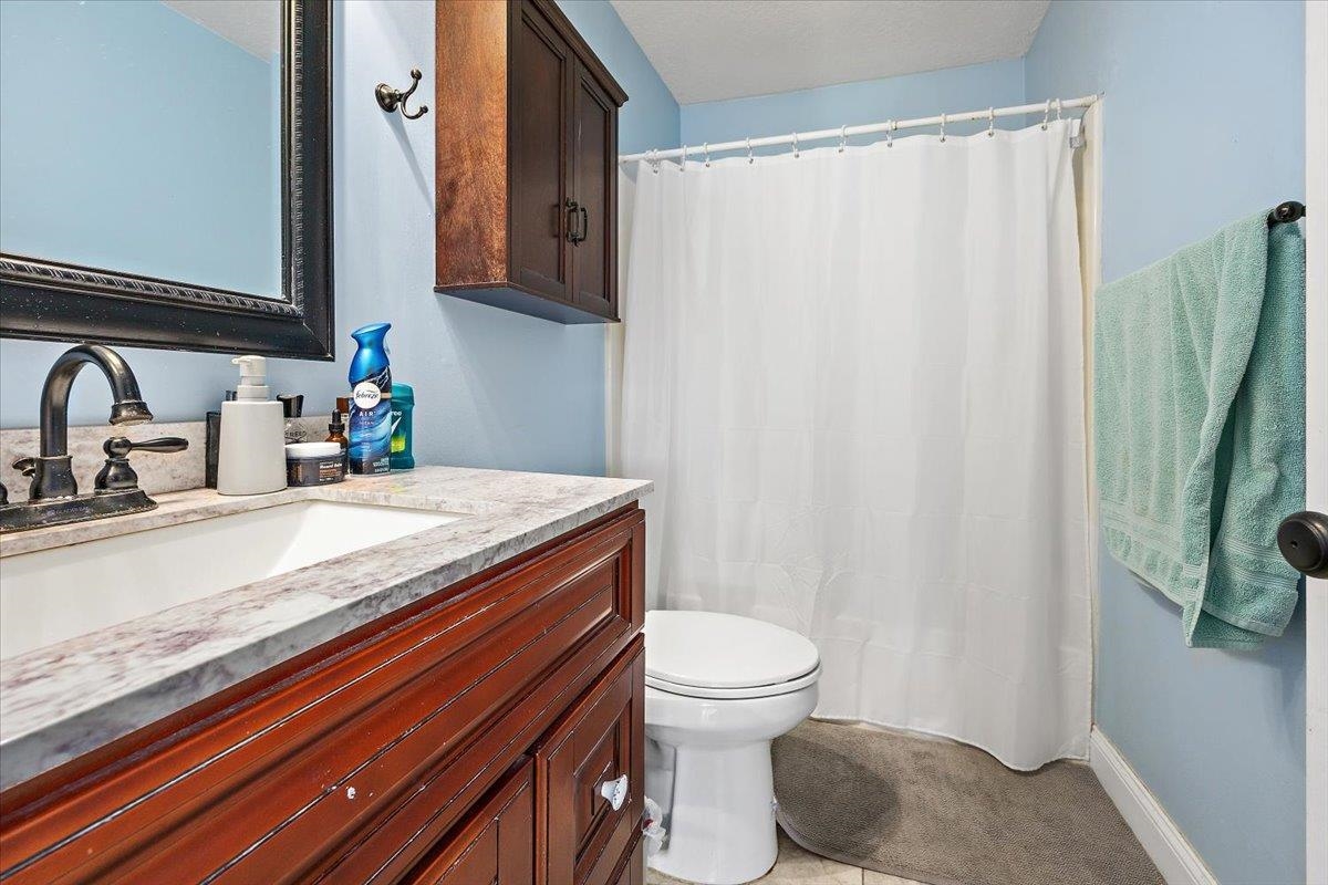 124 Rio Del Mar Street, Unit C St. Augustine, FL 32080 - Photo 15 of 27 a bathroom with a granite countertop sink and a mirror
