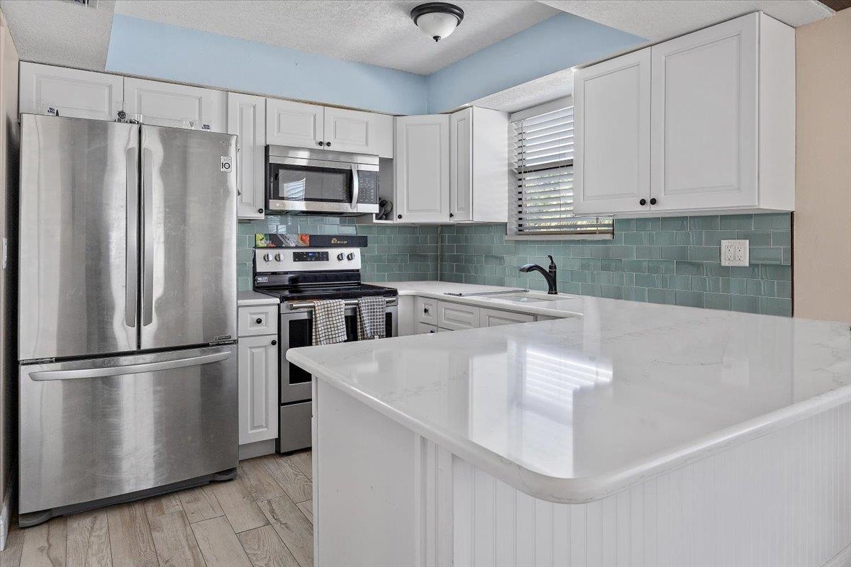 124 Rio Del Mar Street, Unit C St. Augustine, FL 32080 - Photo 6 of 27 a kitchen with stainless steel appliances granite countertop a refrigerator sink and microwave