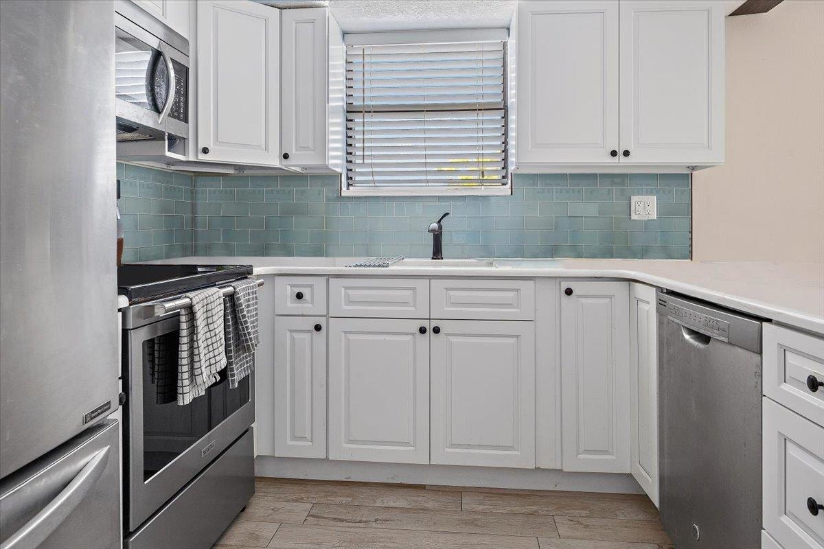 124 Rio Del Mar Street, Unit C St. Augustine, FL 32080 - Photo 7 of 27 a kitchen with white cabinets and white appliances