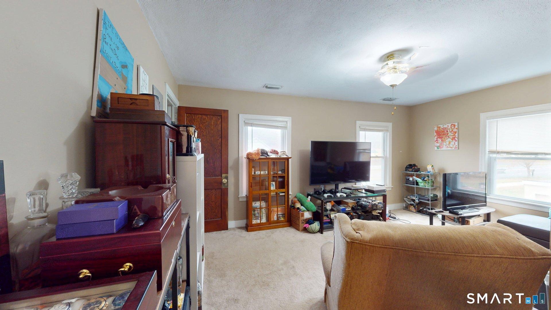 138 Main Street Somers, CT 06071 - Photo 17 of 44 a living room with furniture a flat screen tv and a window