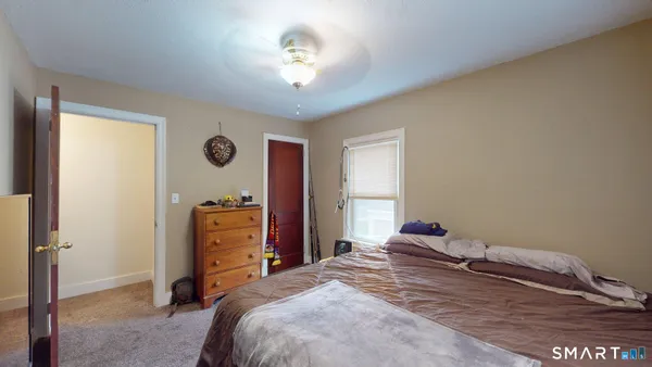 a bedroom with bed and a wooden floor